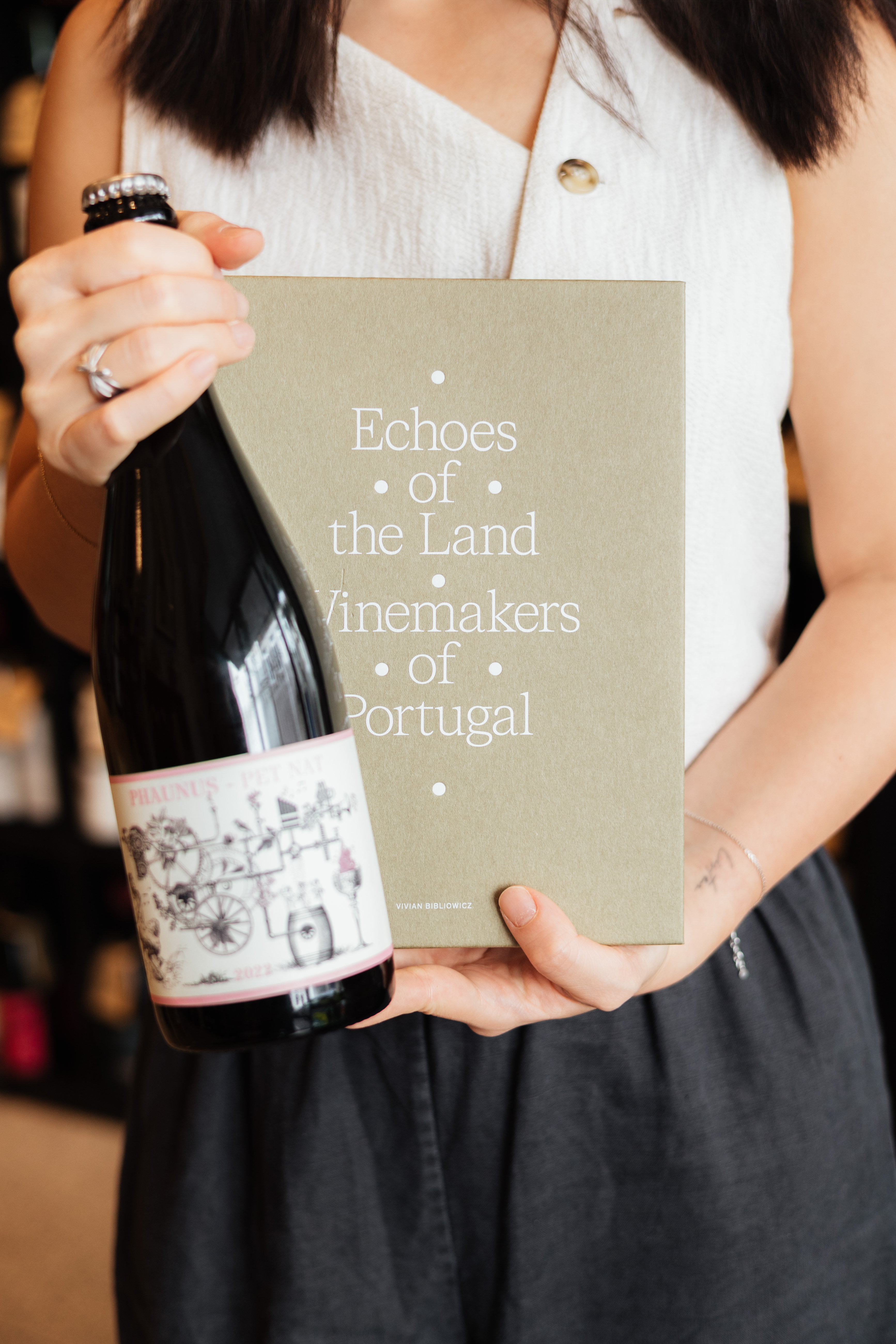 Christine holding wine book and bottle